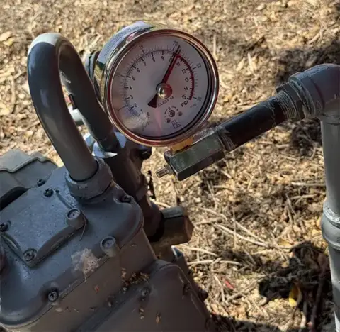 Pressure gauge mounted on a gas line showing temperature and pressure readings during a Frisco plumbing repair