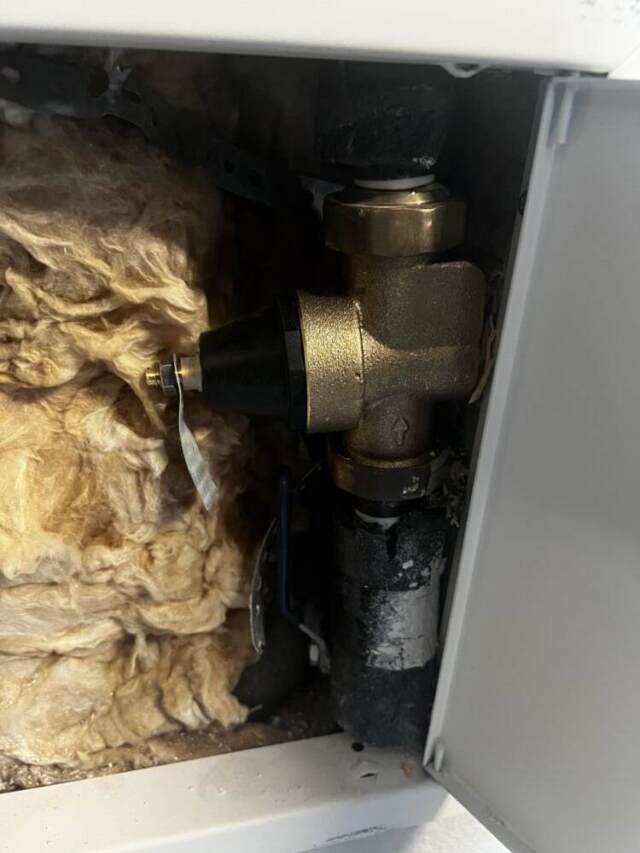 Close-up of the completed PRV replacement inside the garage wall.