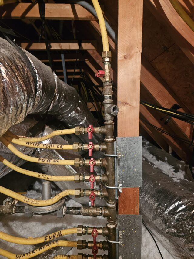 Diagnosing a gas leak in the attic using a pressure gauge connected to the gas manifold near the water heater.