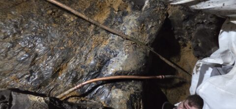 Justin deep under the house repairing leaking pipes