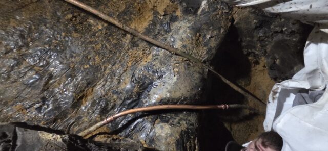 Justin deep under the house repairing leaking pipes