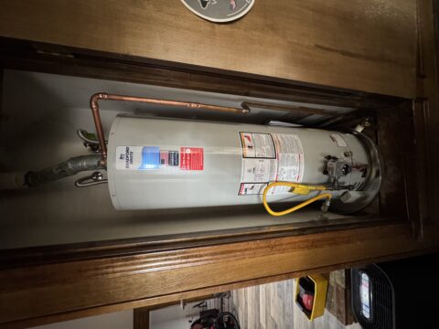 New Bradford White tank water heater installed in Plano home garage with copper piping and safety equipment