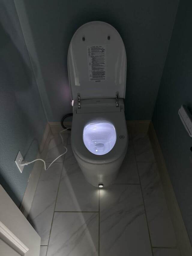 Moen smart toilet glowing at night with built-in night light and modern design.
