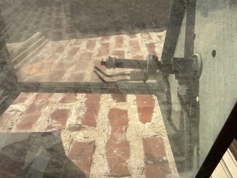 Close-up of a gas lantern jet assembly mounted on brick showing carbon buildup inspection during Frisco plumbing service.