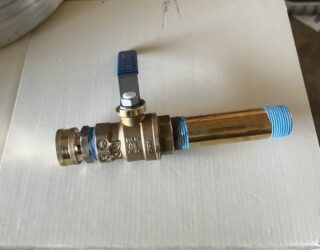 New brass ball valve with blue handle installed on copper water heater drain line for Frisco plumbing service