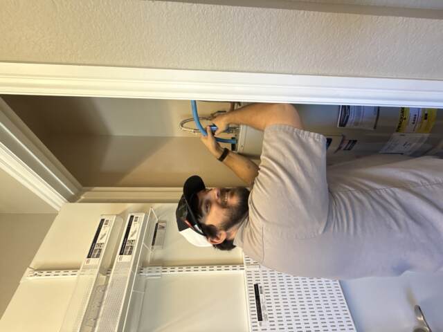 GPS technician installs a brand new water heater