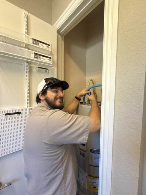 GPS technician installs a brand new water heater
